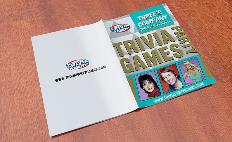 Puede incluir: Un libro azul y dorado con el t&iacute;tulo "Three's Company Trivia Showdown Trivia Games Party" e im&aacute;genes de los tres personajes principales del programa.