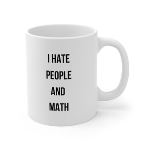 Peut inclure: Tasse en céramique blanche avec l'inscription noire "I HATE PEOPLE AND MATH". La tasse, avec une anse incurvée et une finition brillante, est conçue pour les boissons chaudes.