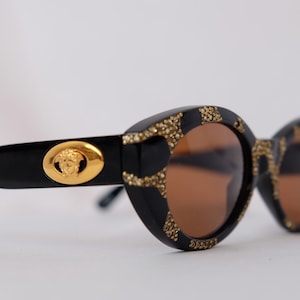 Ultra-rare 1990s vintage Versace MOD. 480 vintage sunglasses in deadstock mint condition – featuring luxurious coral-effect frames, Swarovski crystal embellishments, and iconic gold Medusa logos on both temples, complete with original Versace case, cloth, and authentication card.