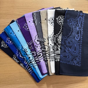 Puede incluir: Una colecci&oacute;n de pa&ntilde;uelos bandana en varios colores, incluyendo azul, morado, gris y negro. Cada pa&ntilde;uelo presenta un dise&ntilde;o de cachemira. Los pa&ntilde;uelos est&aacute;n abanicados, mostrando los diferentes colores y patrones.