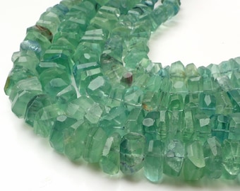 May include: A strand of light green faceted gemstone beads. The beads are irregular in shape and have a slightly translucent appearance.