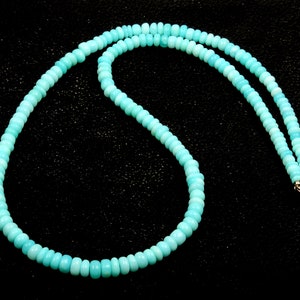 May include: A turquoise blue beaded necklace with a silver clasp.