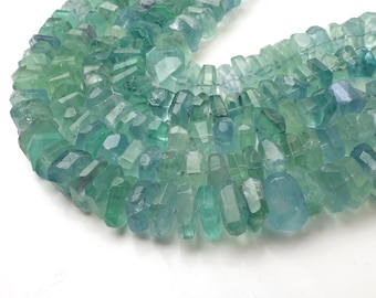 May include: A strand of light blue and green faceted gemstone beads. The beads are irregular in shape and have a slightly translucent appearance.