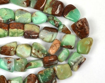 May include: A strand of green and brown chrysoprase gemstone beads. The beads are irregularly shaped and have a polished finish.