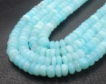 May include: Strands of light blue gemstone beads. The beads are round and have a slightly flattened shape. The color varies from a pale, almost white, to a deeper sky blue. The beads are strung together, creating a necklace or bracelet.