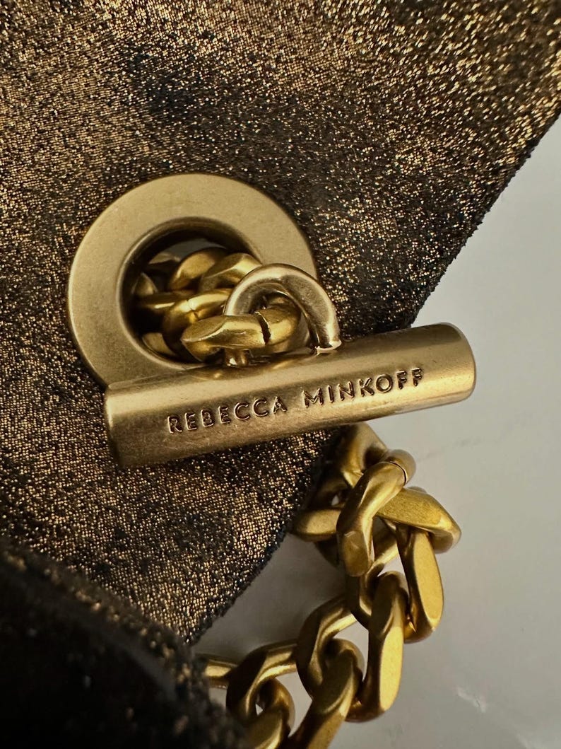 May include: A white ceramic mug with a black handle and the text "But First, Coffee" in a black, handwritten-style font. The mug is on a white surface.