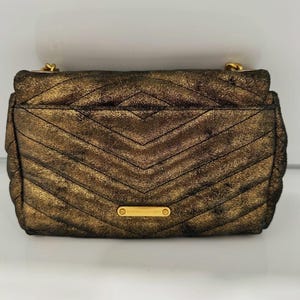 May include: A set of three ceramic mugs with a speckled, matte finish. The mugs are in shades of cream, light gray, and dark gray. Each mug has a simple, minimalist design and a rounded handle.