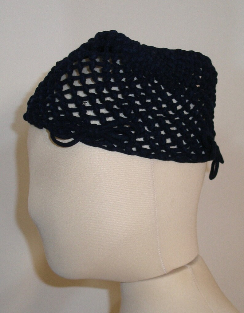 May include: A navy blue crocheted hat with a wide brim and a loose, open weave. The hat has a simple design and is made of a soft, comfortable material.
