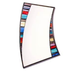 May include: A curved mirror with a colorful mosaic frame. The frame is made of small, rectangular pieces of glass in various shades of blue, red, yellow, and green.