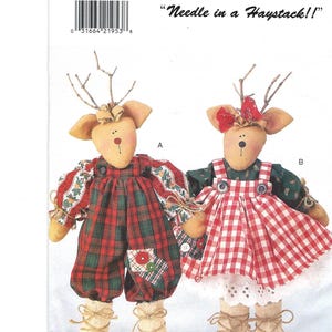 May include: Two handmade reindeer dolls. One doll wears red and green plaid overalls, the other a red and white checkered dress. Both have twig antlers, tan ears, and are labeled "Needle in a Haystack!!"