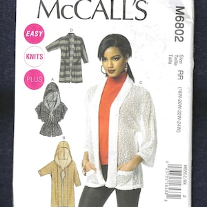 Peut inclure: Patron de couture McCall's M6802 pour la taille RR (18W-20W-22W-24W) proposant trois styles différents de cardigans en tricot. Le patron comprend des instructions pour un cardigan à capuche avec une ceinture à nouer, un cardigan long avec des poches et un cardigan plus court avec un col châle. Le patron est étiqueté "Facile" et "Grande Taille".