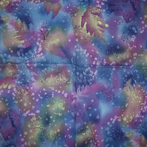 May include: Abstract fabric with a blue, purple, and green color scheme. The fabric has a mottled, splatter-painted design with white dots.
