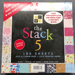 May include: A package of 180 acid and lignin free 12x12 inch printed paper sheets. The package is labeled "The Stack 5" and features a variety of colorful patterned paper samples. The package is from DCWV and includes a website address and a value pack label.
