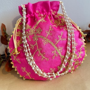 Bolso potli bordado a mano en rosa y dorado