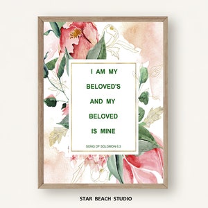 May include: A watercolor print with pink and green flowers and gold accents. The print features a quote from the Song of Solomon: "I am my beloved's and my beloved is mine." The print is framed in a light wood frame.