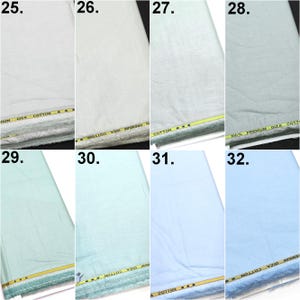 May include: A collection of eight fabric swatches labeled 25 through 32, featuring various shades of white, light green, and light blue. Each piece of Giza cotton fabric displays a yellow selvage edge with the printed text GIZA COTTON.