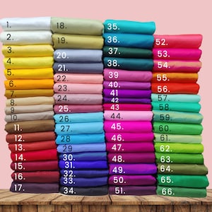 Op de afbeelding: Een stapel van 66 stofstalen in verschillende kleuren, genummerd van 1 tot en met 66. De stalen zijn gerangschikt in kolommen, waarbij elke kolom een andere kleur bevat.