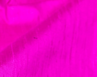 May include: A close-up of a bright pink fabric with a smooth, silky texture.