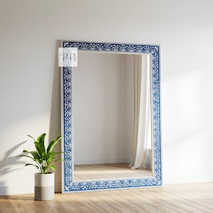 May include: A large, full-length mirror with a blue and white painted frame. The frame features a floral design with white flowers on a blue background.