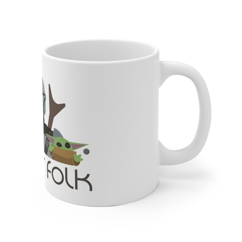 May include: White ceramic mug featuring a cartoon image of a Mandalorian and a Baby Yoda character. The text "This is the way" is printed on the mug.
