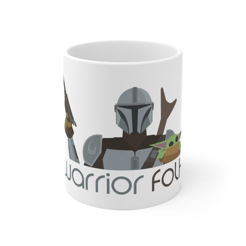 May include: White ceramic mug featuring a cartoon illustration of a Mandalorian warrior, a green alien, and the text "warrior folk".