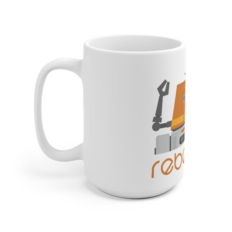 May include: White ceramic mug featuring a cartoon illustration of a robot with an orange head and the text "rebels" in orange.