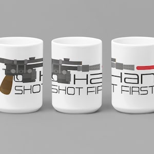May include: White ceramic mug with a black and gray illustration of a blaster pistol and the text "Han Shot First".