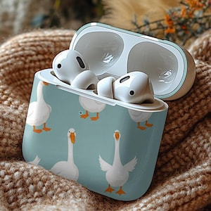 May include: A white wireless charging case with a blue and white goose print design. The case is open and the earbuds are visible.