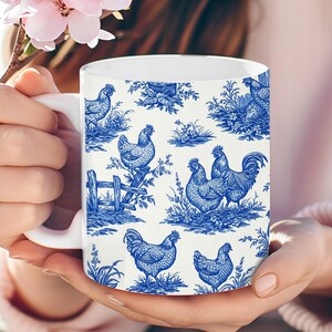 May include: White ceramic mug with a blue and white pattern of roosters and hens. The pattern is a toile design with a white background and blue roosters, hens, and floral accents.