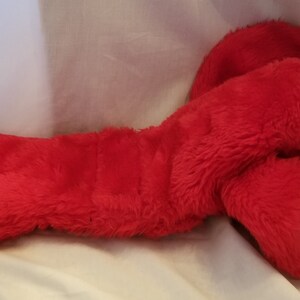 May include: A red plush lobster toy with a soft, fuzzy texture. The lobster is lying on its side with its claws curled up.