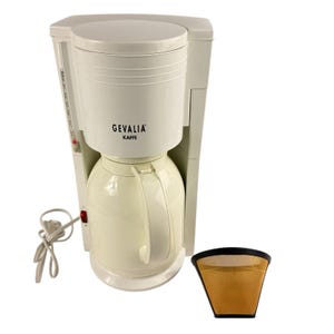 May include: Off-white GEVALIA Kaffe coffee maker with a thermal carafe and a separate filter. The coffee maker has a power cord and a red power button. The GEVALIA logo is printed on the front.