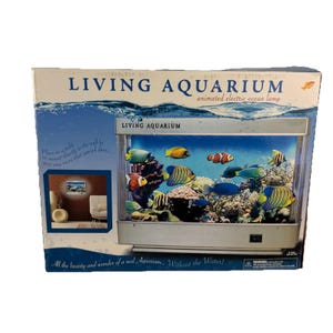 May include: A rectangular Living Aquarium animated electric ocean lamp box featuring a graphic of a fish tank with colorful tropical fish, coral, and rocks. The packaging includes the text Living Aquarium and All the beauty and wonder of a real Aquarium.. Without the Water!