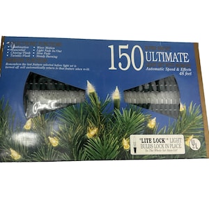 May include: A rectangular product box for a 150-count light set measuring 48 feet in length. The blue packaging features text including 150 Ultimate, electronic functions, and Lite Lock. The box displays a graphic of lit bulbs on pine branches.