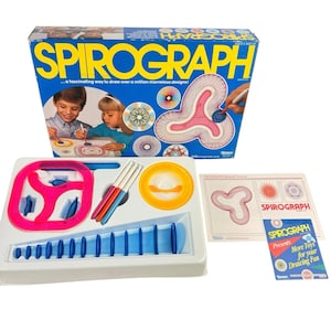 May include: A vintage Spirograph drawing toy set. The box is blue and yellow with the word "SPIROGRAPH" in large letters. The set includes drawing tools, stencils, and examples of designs. The text on the box reads "...a fascinating way to draw over a million marvelous designs!"