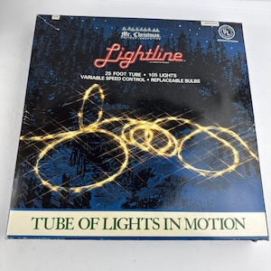 May include: A square product box for Mr. Christmas Lightline, a 25-foot tube with 105 lights. The dark blue box features a graphic of glowing yellow lights in motion, with text stating variable speed control and replaceable bulbs included.