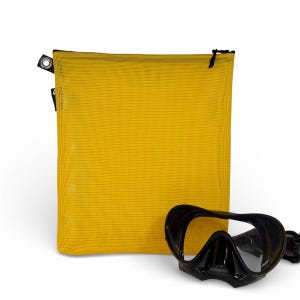 Op de afbeelding: Een gele mesh tas met zwarte randen en een zwart duikmasker. De tas heeft een rechthoekige vorm en een ritssluiting. Het duikmasker is zwart met een heldere lens.