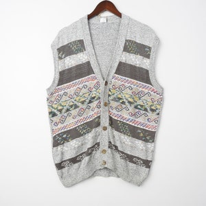 May include: A gray sleeveless knitted cardigan with a geometric pattern in brown, white, blue, yellow, and red. The cardigan has a V-neck and button closure.