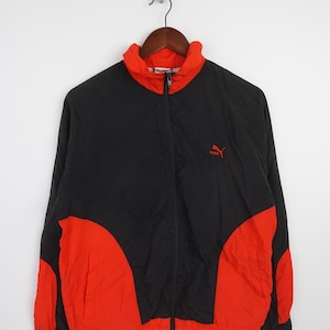 May include: A black and red windbreaker jacket with a zipper closure and a Puma logo on the chest.