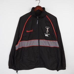 May include: Black windbreaker jacket with red and gray accents. The jacket has a zipper closure and a hood. The logo "KooGa" is on the left side of the chest and the logo "HARLEQUINS RL" is on the right side of the chest.