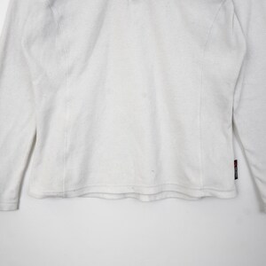 Op de afbeelding: Wit shirt met lange mouwen. Het shirt heeft een ronde hals en een eenvoudig ontwerp. De mouwen zijn lang en eindigen bij de polsen. Het shirt is gemaakt van een zacht, comfortabel materiaal. Het shirt is effen wit.