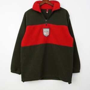 May include: A green and red fleece pullover with a zip fastening and a patch logo that reads "Alpine Expedition".