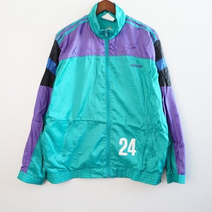 May include: A vintage Adidas track jacket in teal, purple, and black with a white number 24 on the front. The jacket has a zipper closure and a stand-up collar.