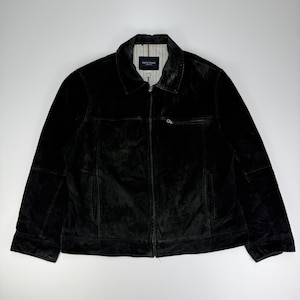 May include: A black suede jacket featuring a full-length front zipper, a pointed collar, and two lower side pockets. The jacket includes a single zippered chest pocket on the left side and a light-colored interior lining with vertical pinstripes.