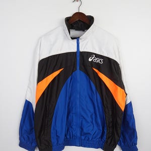 May include: A white, black, blue, and orange windbreaker jacket with the word "ASICS" in white on the front.