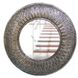 Puede incluir: Un espejo redondo con un marco plateado que presenta un diseño detallado de plumas. El espejo refleja una imagen borrosa de una escalera.