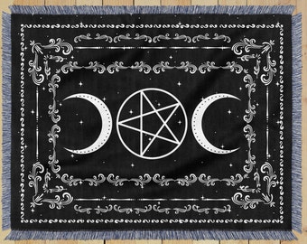 Op de afbeelding: Zwart-witte wandkleed met een pentagram en twee halve manen in het midden. Het wandkleed is omgeven door een decoratieve rand van spiralen en lijnen.