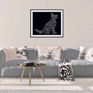 May include: A gray couch with pillows and a throw blanket in front of a white wall with a framed black and white geometric dog illustration.