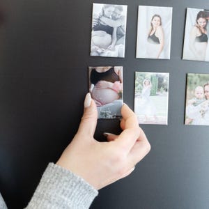 a person holding a cell phone in front of a wall