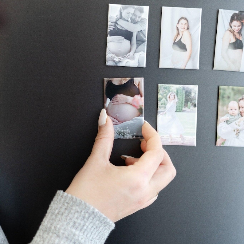 a person holding a cell phone in front of a wall