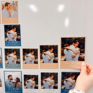 a hand holding a small card with a photo of a couple embracing, surrounded by other similar cards.